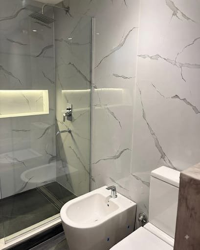 Baño rediseñado con placas de PVC simil mármol